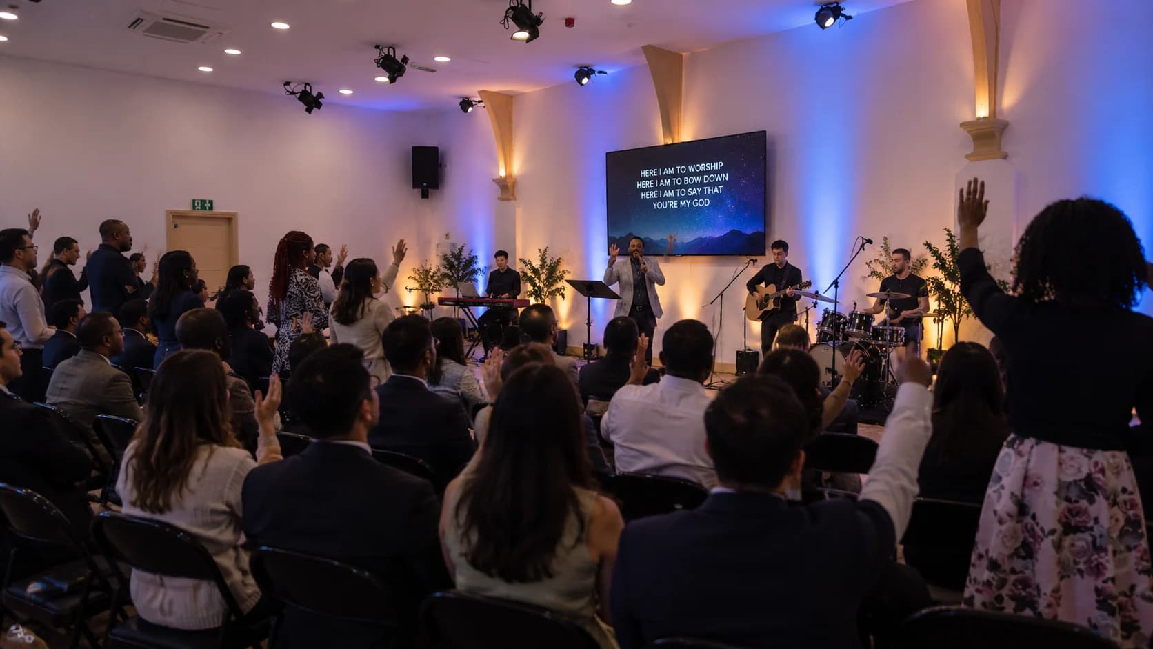 Modern worship service at Grace Hall Leicester with congregation raising their hands in praise